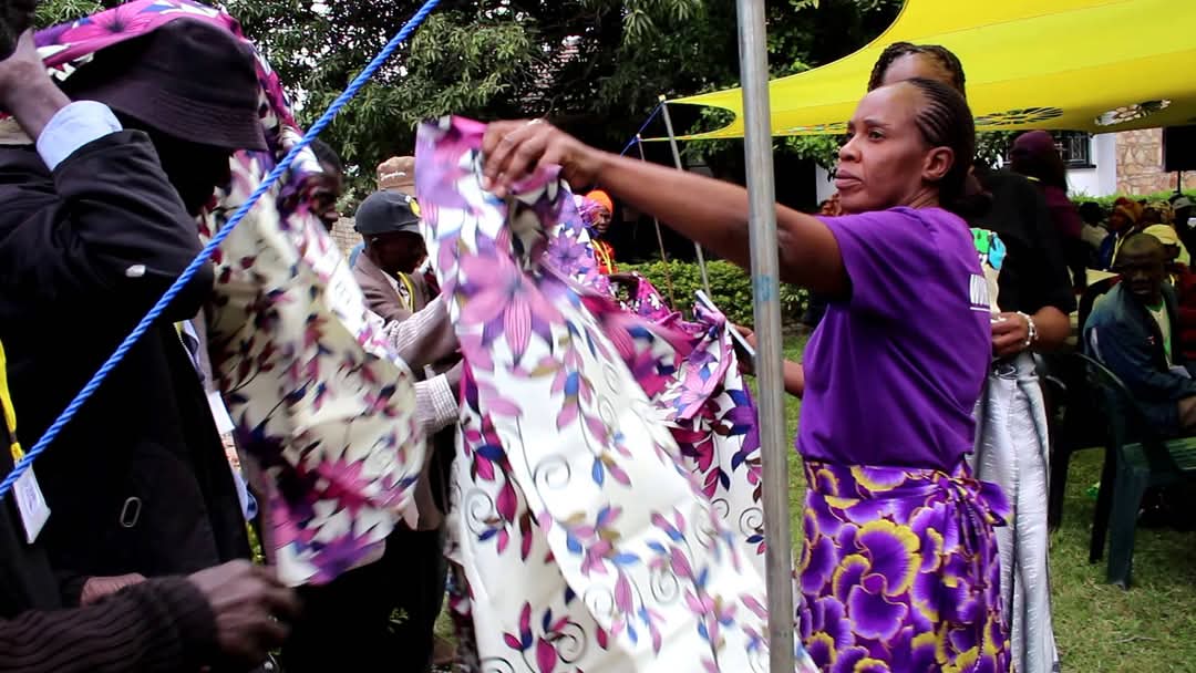The volunteers are distributing floral cloth to everyone. The volunteers are distributing floral cloth to everyone.
