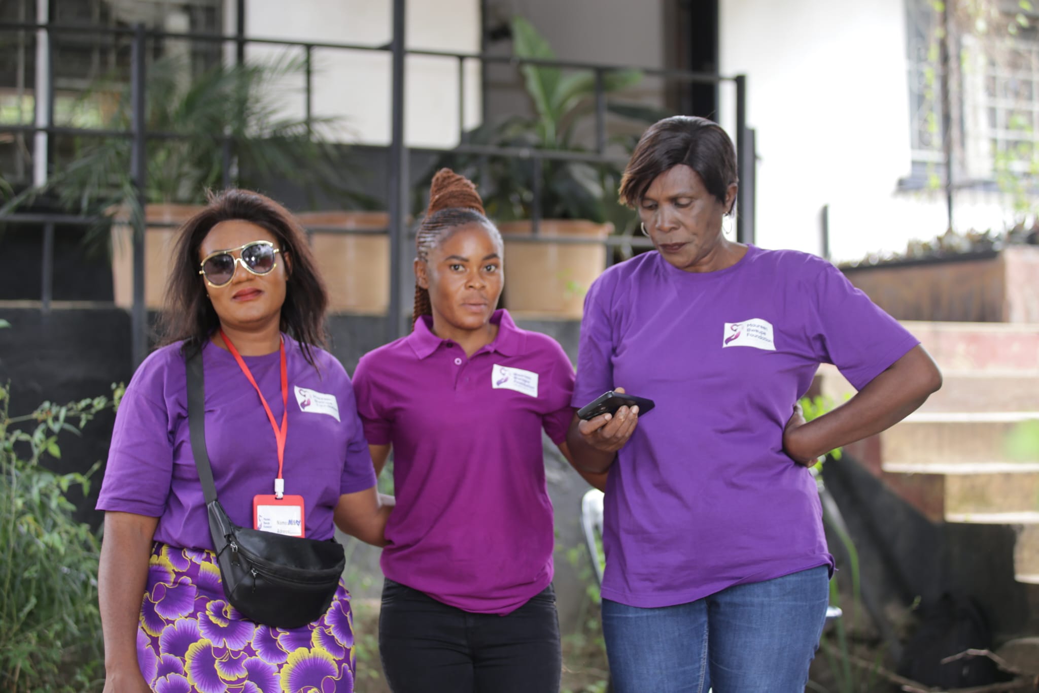 three volunteers in their purple uniform